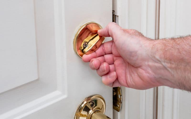 man locking deadbolt door lock on
