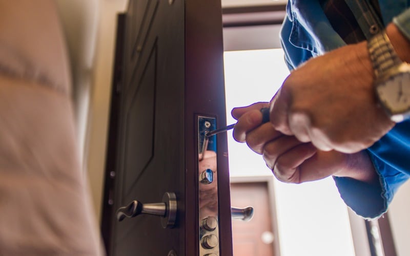 mature laborer fixing door lock