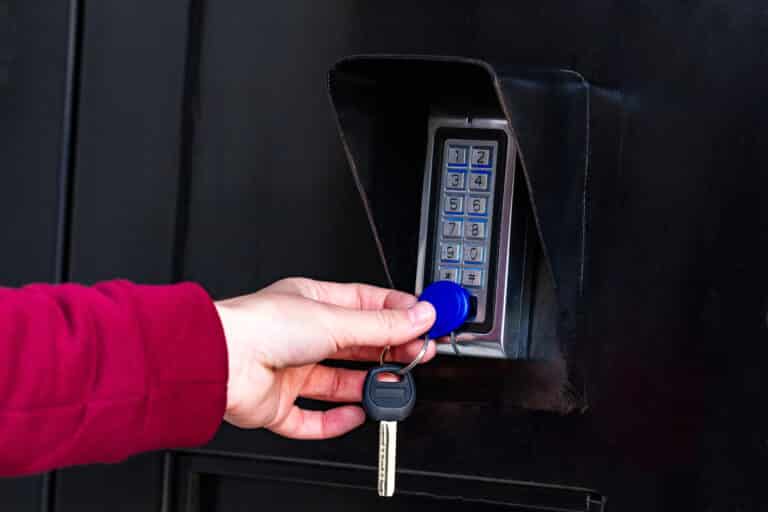 Hand using key fob for keypad entry system - D and L Locksmith